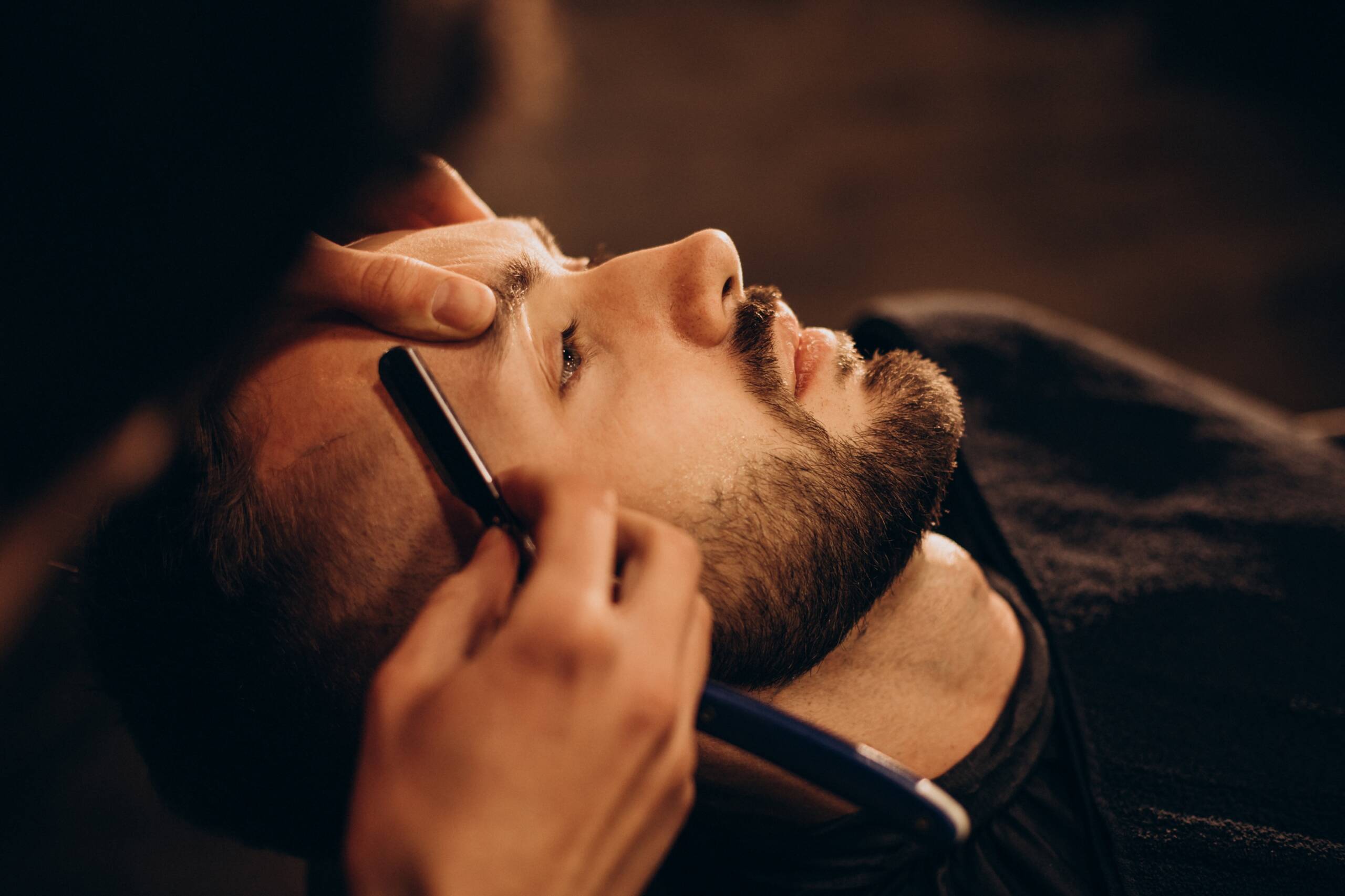 Handsome Man Shaving Beard At Salon